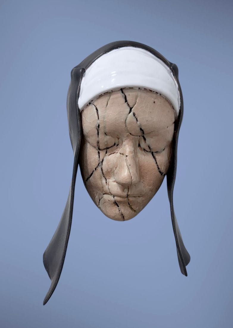 Devotion, a cracked raku-fired ceramic wall mask by Ireri Krueger of a veiled face