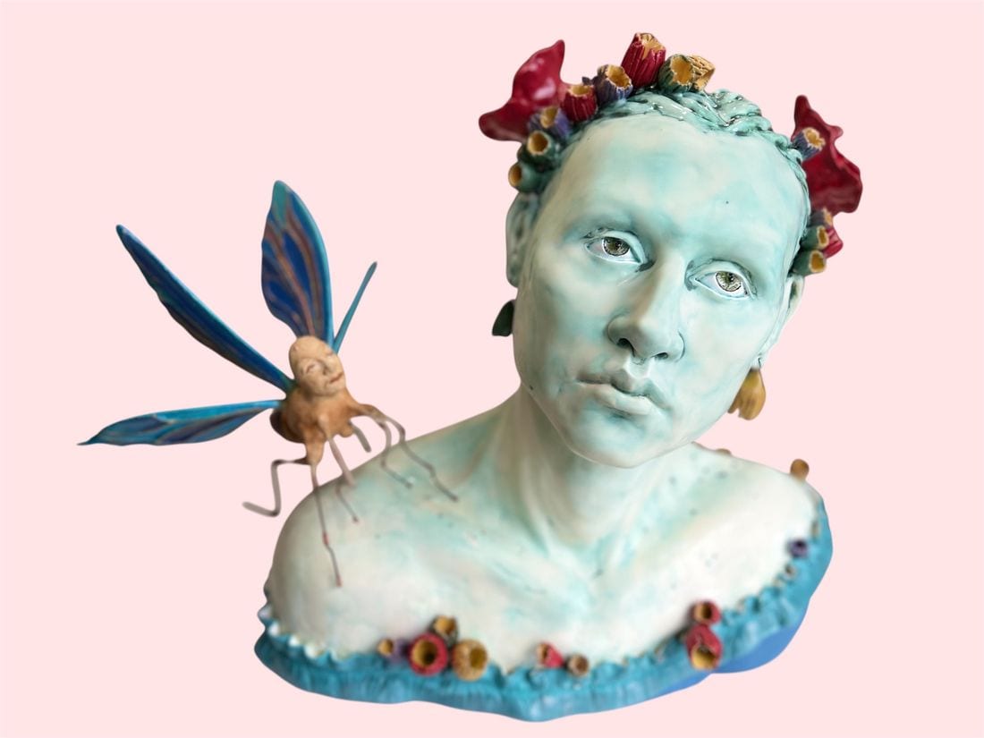 The Visitor, a turquoise ceramic bust by Ireri Krueger with a flower crown and a winged fairy figure